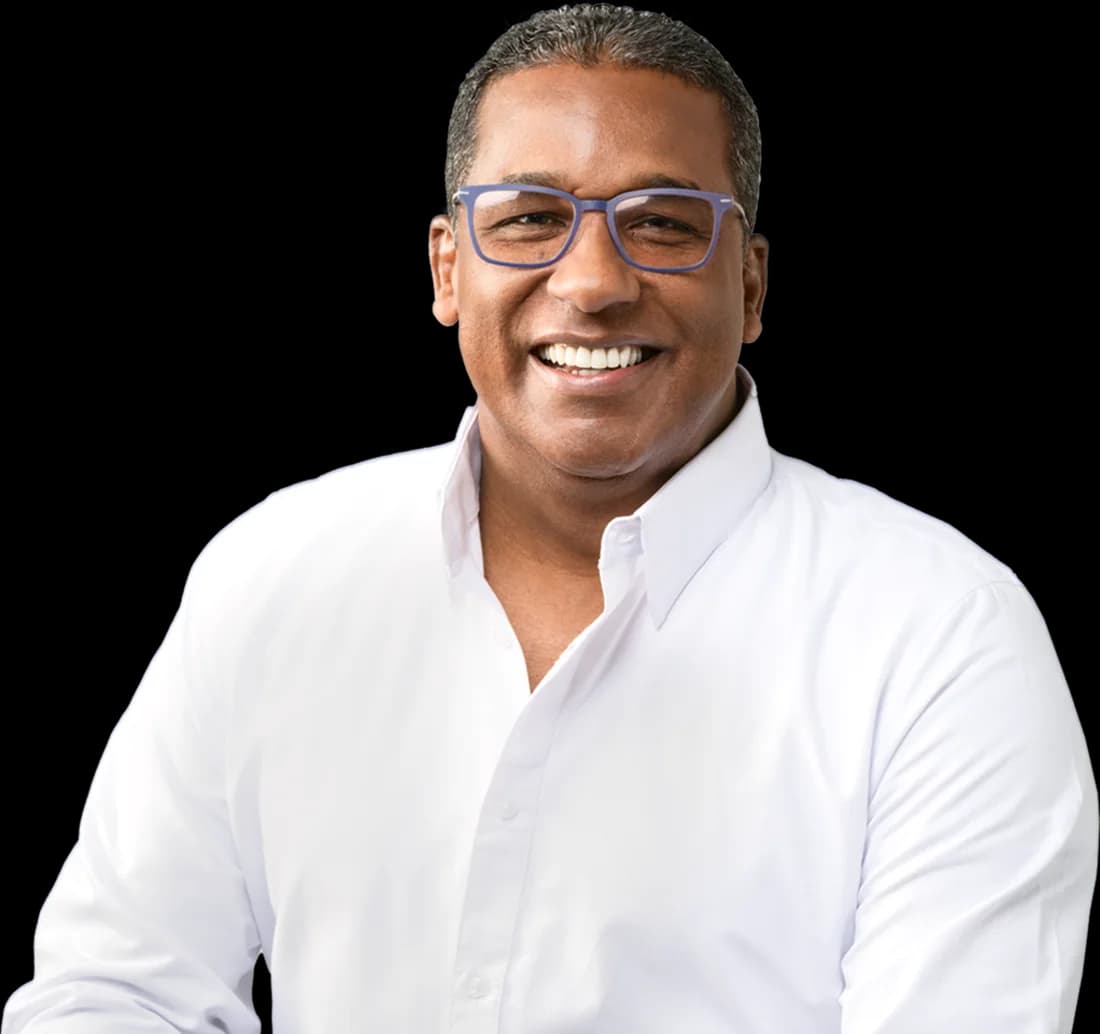 Dr. Agustín Burgos sonriendo, con camisa blanca y lentes